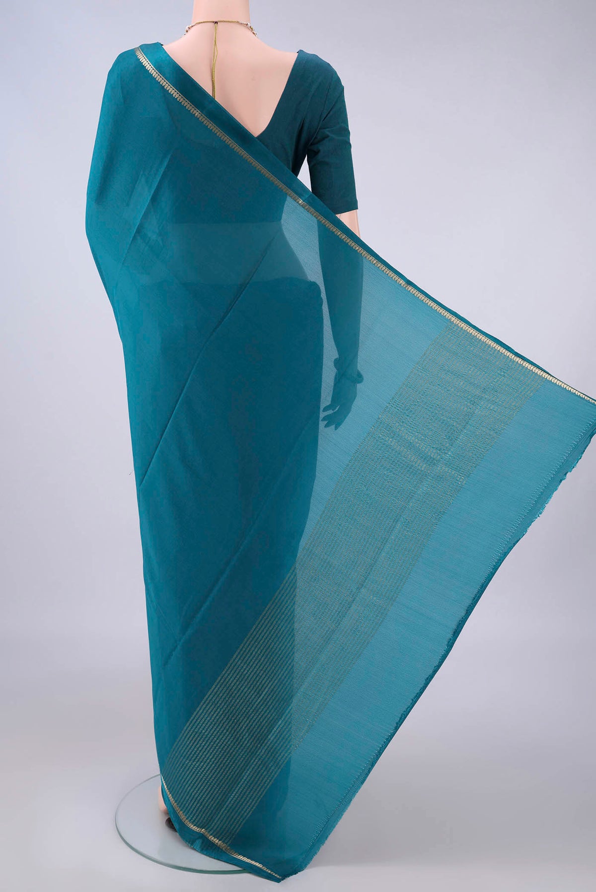 Flat view of Peacock Blue Mysore Crepe Saree with Plain Body and Thin Zari Line. 