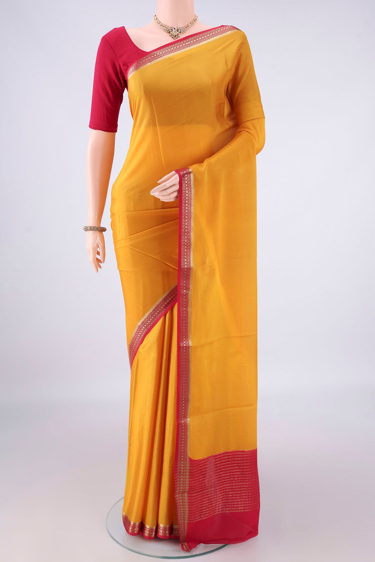 Mustard Mysore Crepe Saree with Plain Body and Zari Border.  displayed on a mannequin