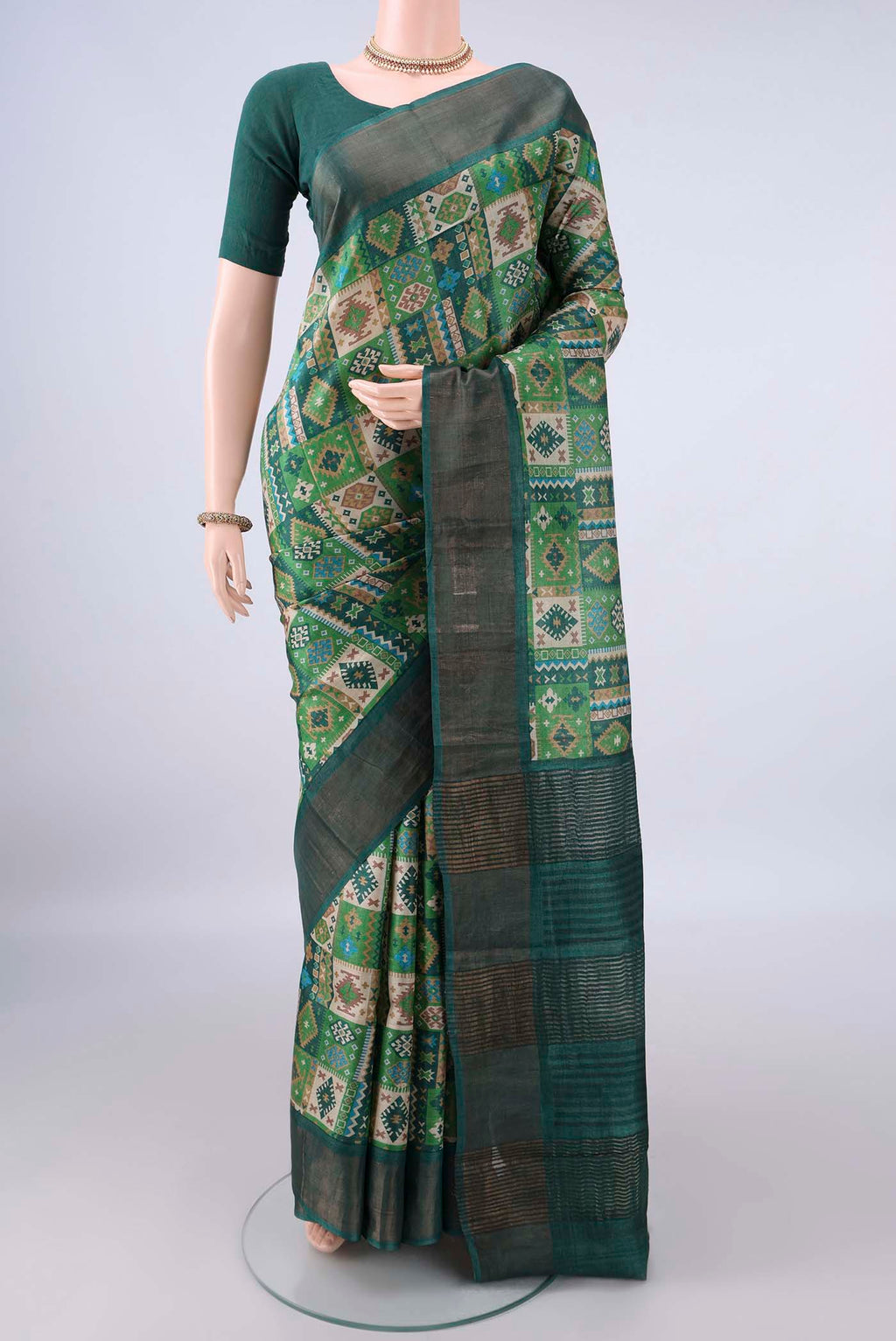 Green Tussar Saree with Printed design on the body and Zari Border.  displayed on a mannequin