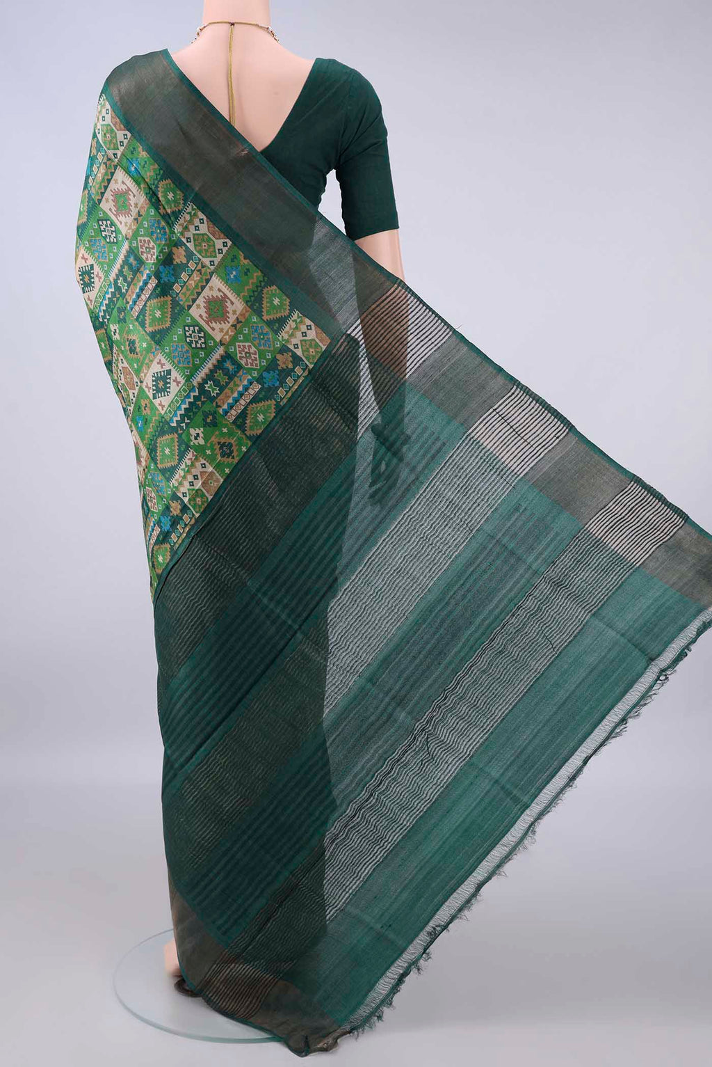 Flat view of Green Tussar Saree with Printed design on the body and Zari Border. 