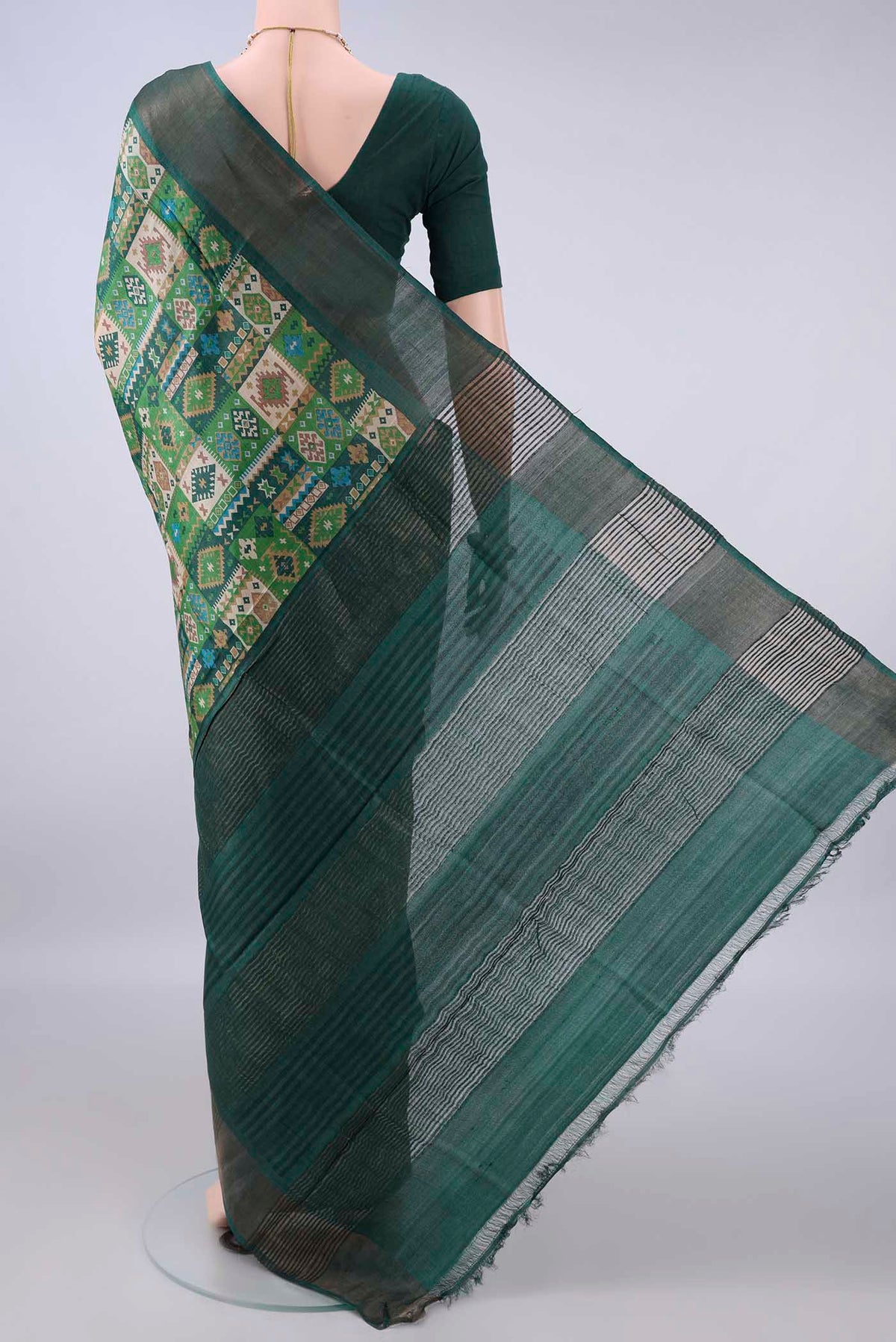 Flat view of Green Tussar Saree with Printed design on the body and Zari Border. 