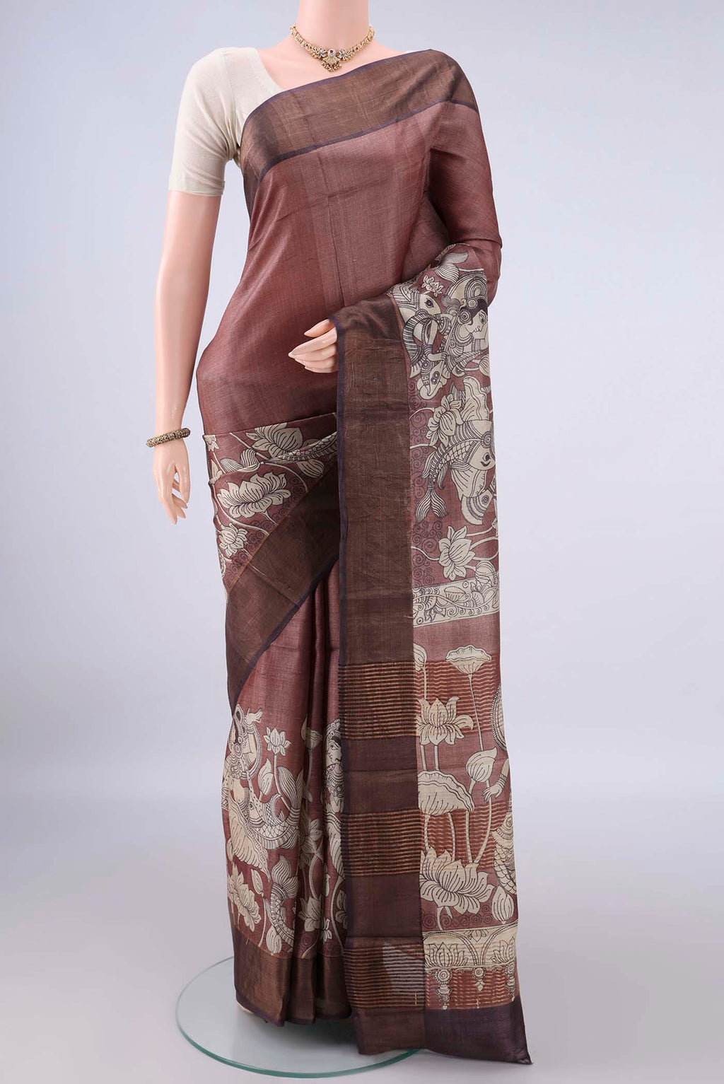 Brown Tussar Saree with Printed design on the body and Zari Border.  displayed on a mannequin