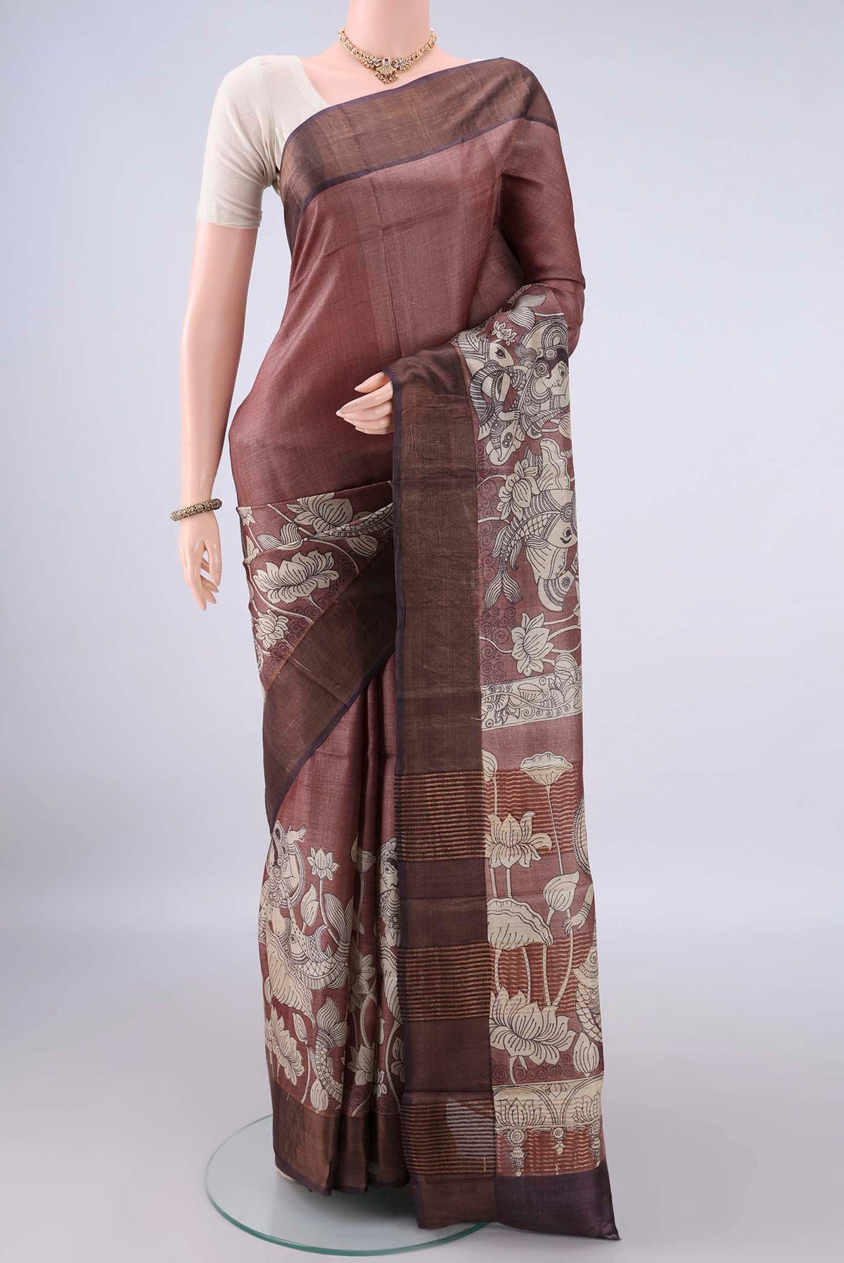 Brown Tussar Saree with Printed design on the body and Zari Border.  displayed on a mannequin