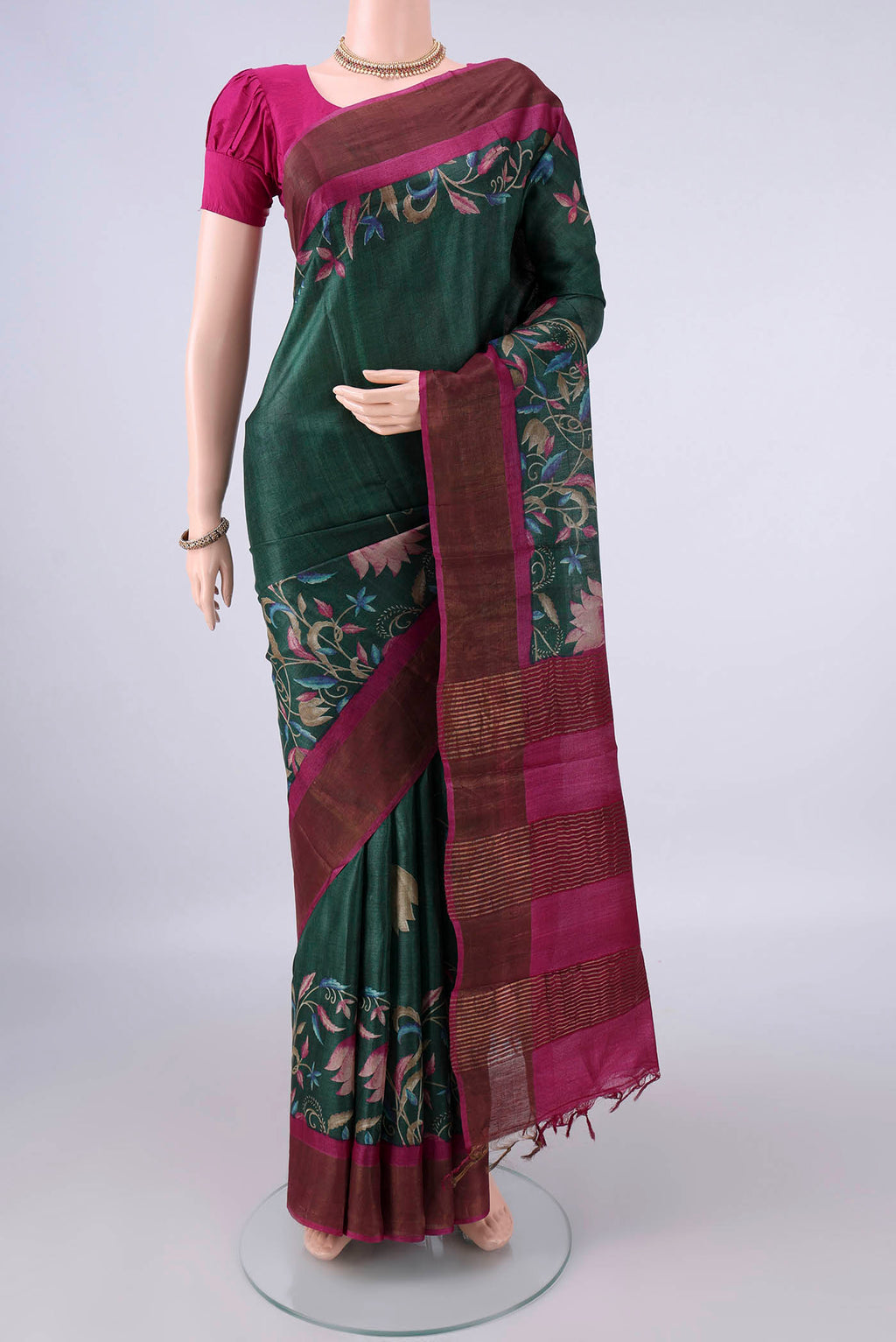 Bottle Green Tussar Saree with Printed design on the body and Zari Border.  displayed on a mannequin