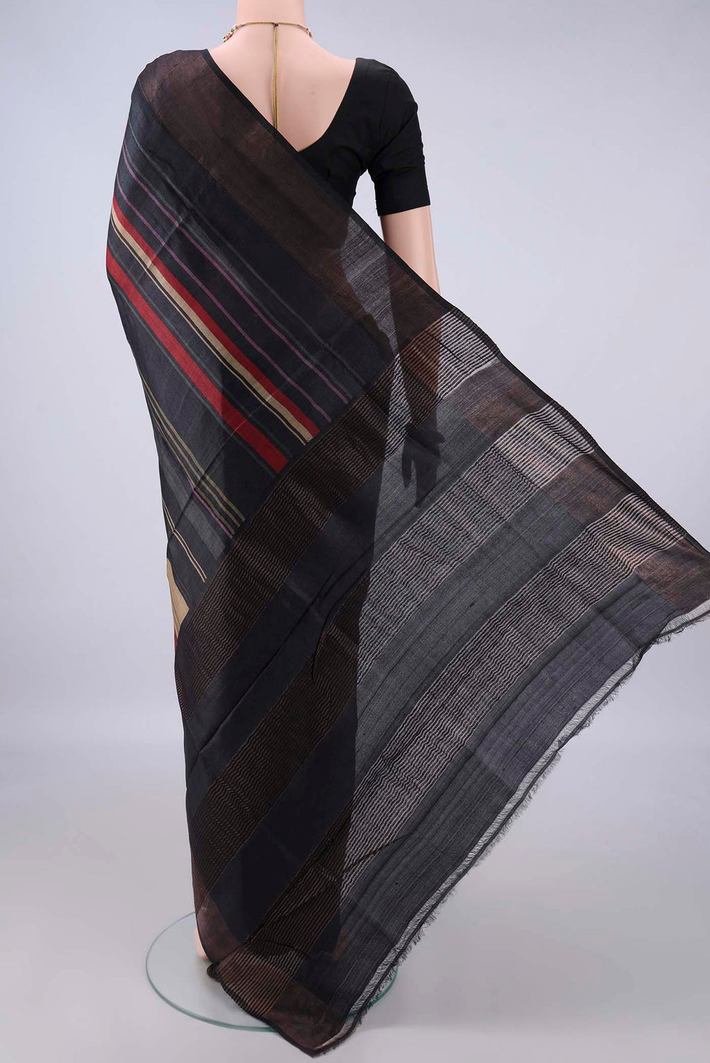 Flat view of Black Tussar Saree with Printed design on the body and Zari Border. 