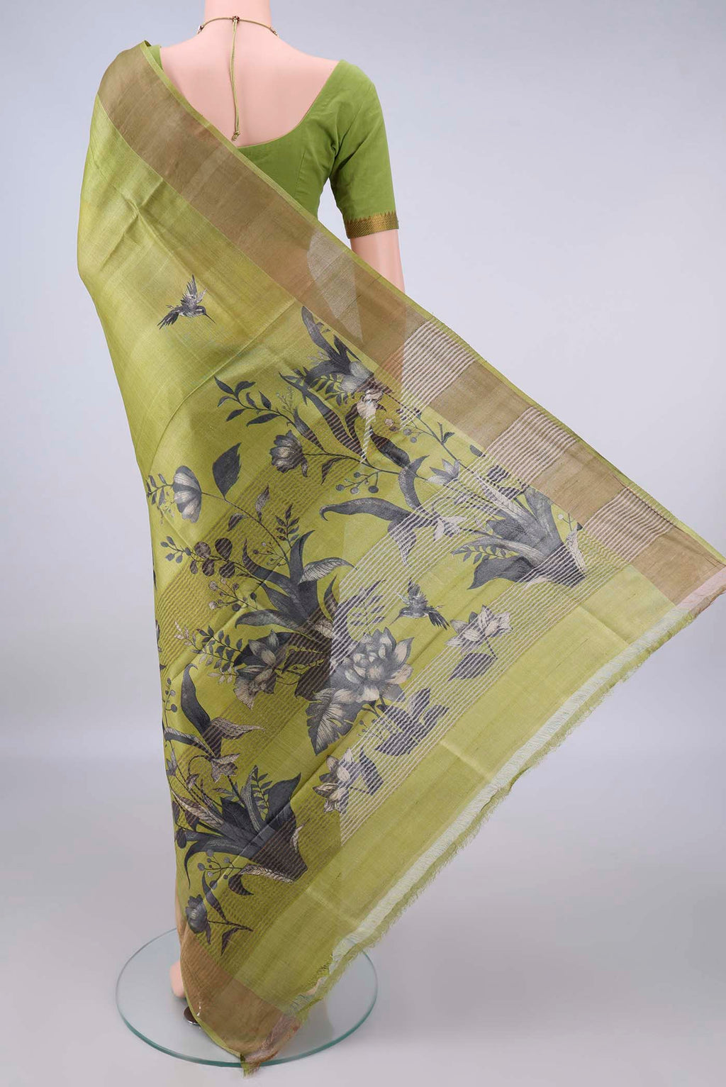 Flat view of Light Green Tussar Saree with Printed design on the body and Zari Border. 
