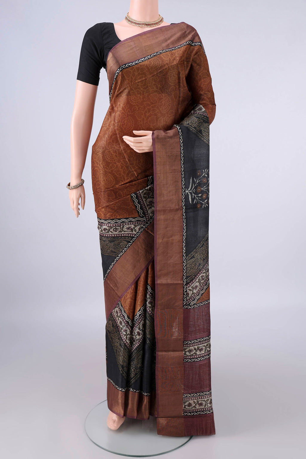 Bronze Tussar Saree with Printed design on the body and Zari Border.  displayed on a mannequin