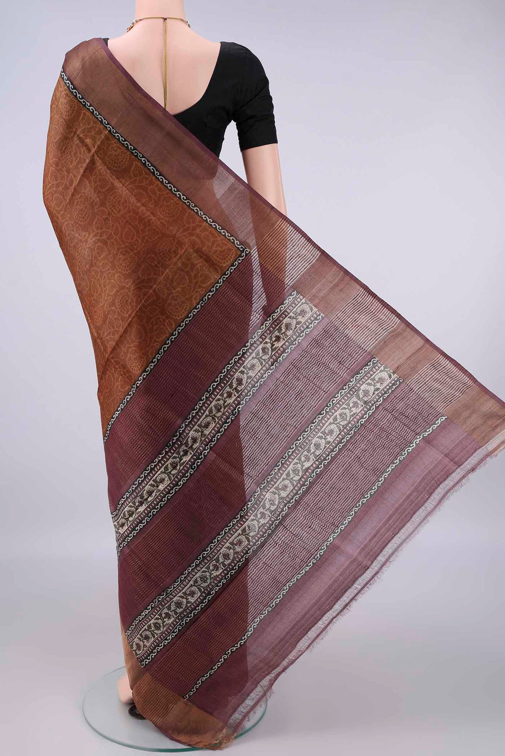 Flat view of Bronze Tussar Saree with Printed design on the body and Zari Border. 