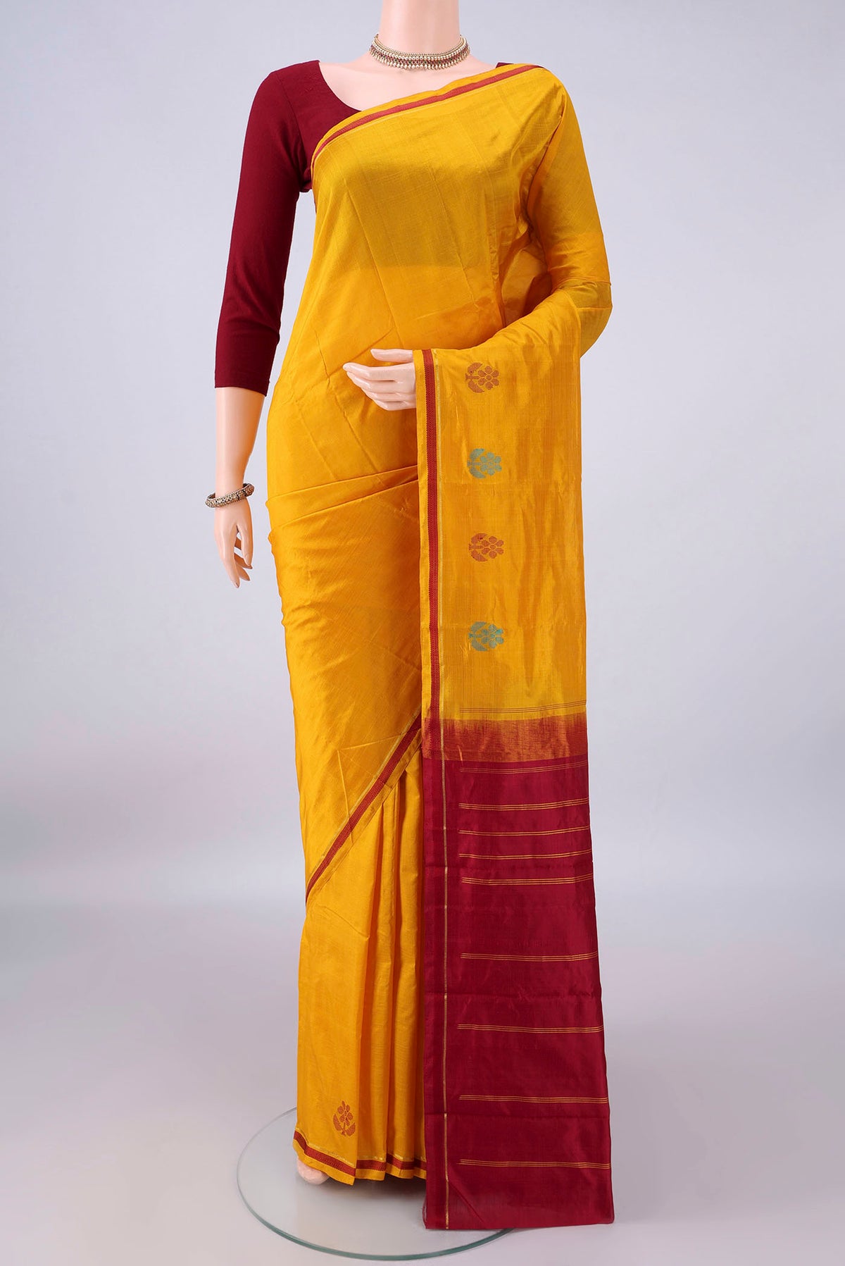Pure Silk Mustard Kanchipuram Saree with Plain Body and Zari Border.  displayed on a mannequin