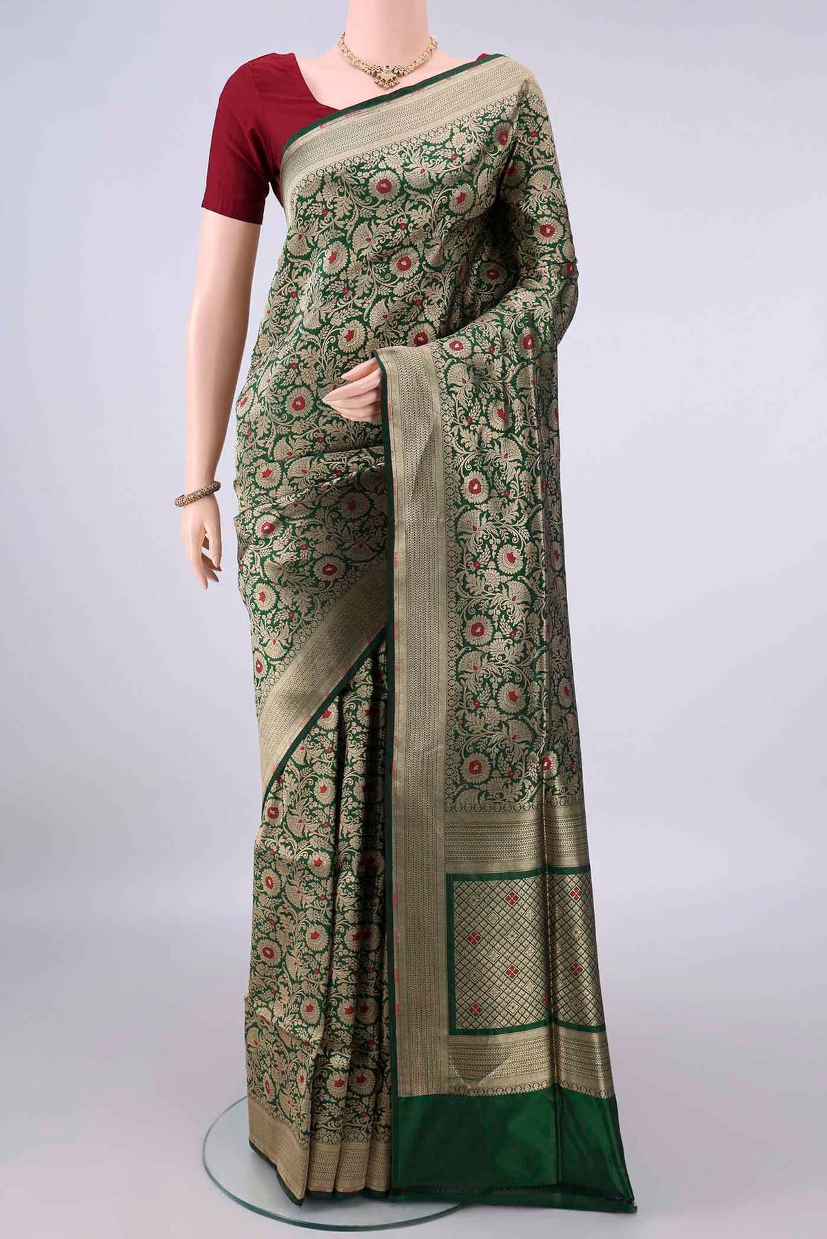 Pure Silk Bottle Green Banarasi Saree with Zari Brocade on the body and Zari Border.  displayed on a mannequin