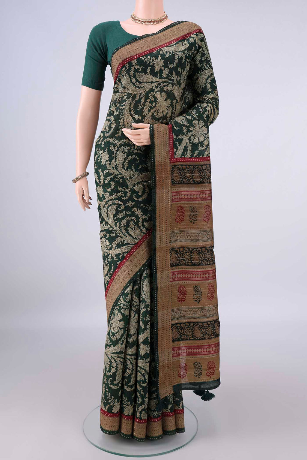 Bottle Green Tussar Saree with Printed design on the body and Zari Border.  displayed on a mannequin