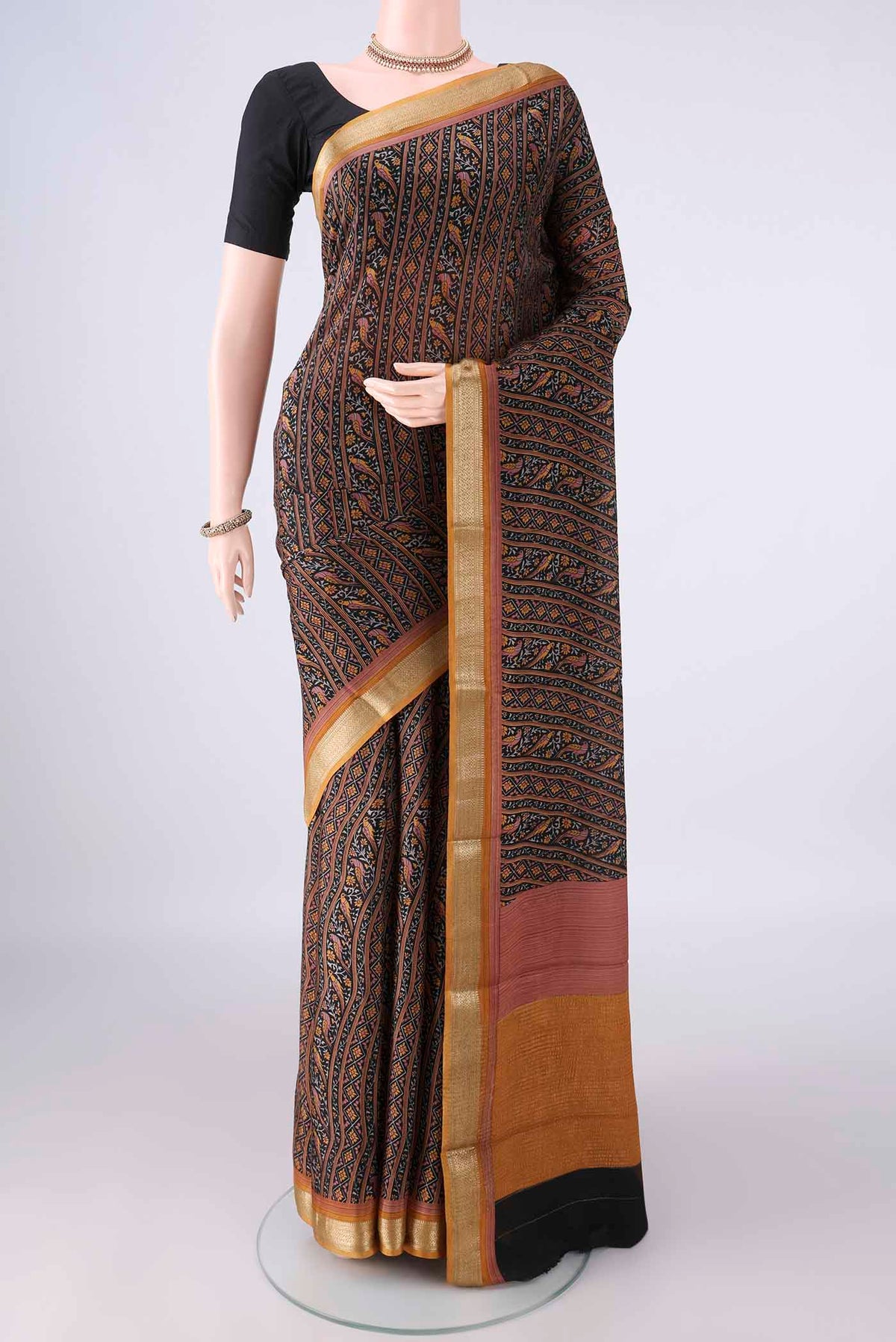 Black Mysore Crepe Saree with Printed design on the body and Zari Border.  displayed on a mannequin