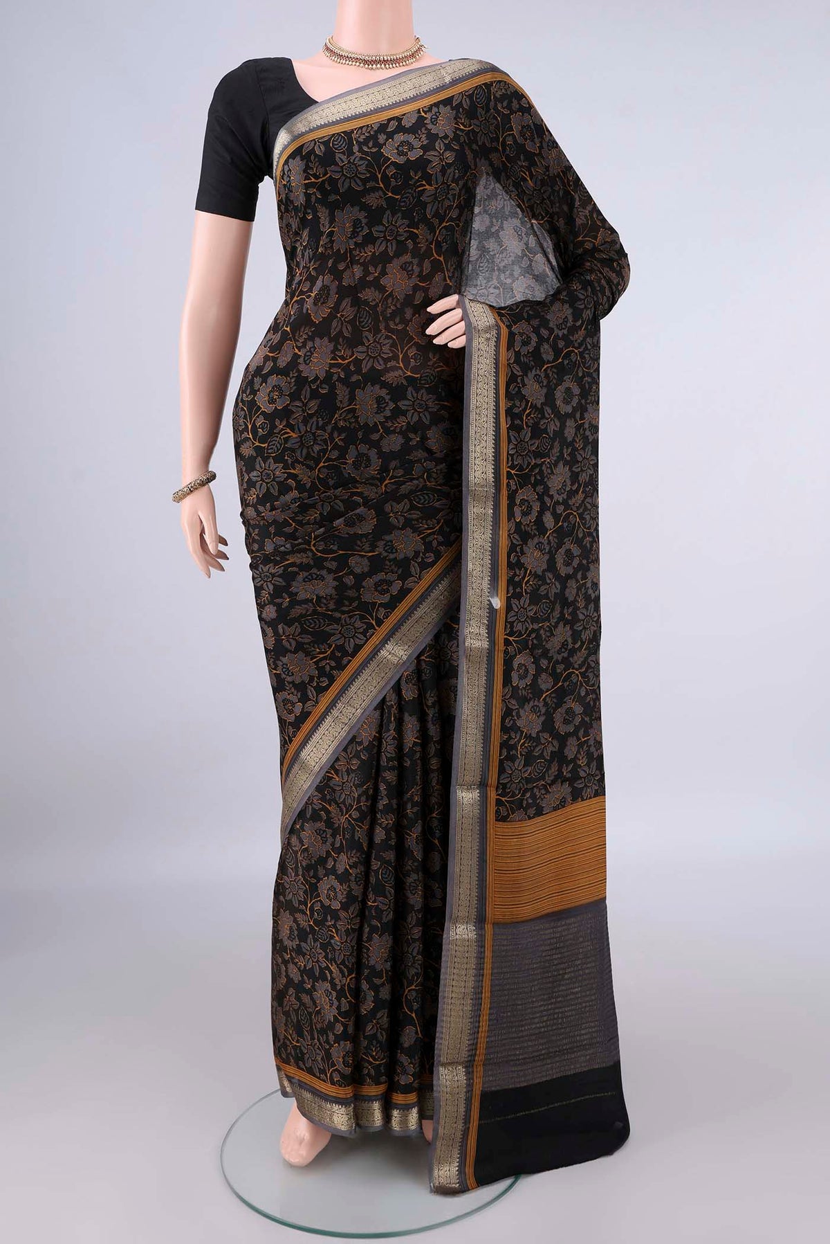 Black Mysore Crepe Saree with Printed design on the body and Zari Border.  displayed on a mannequin