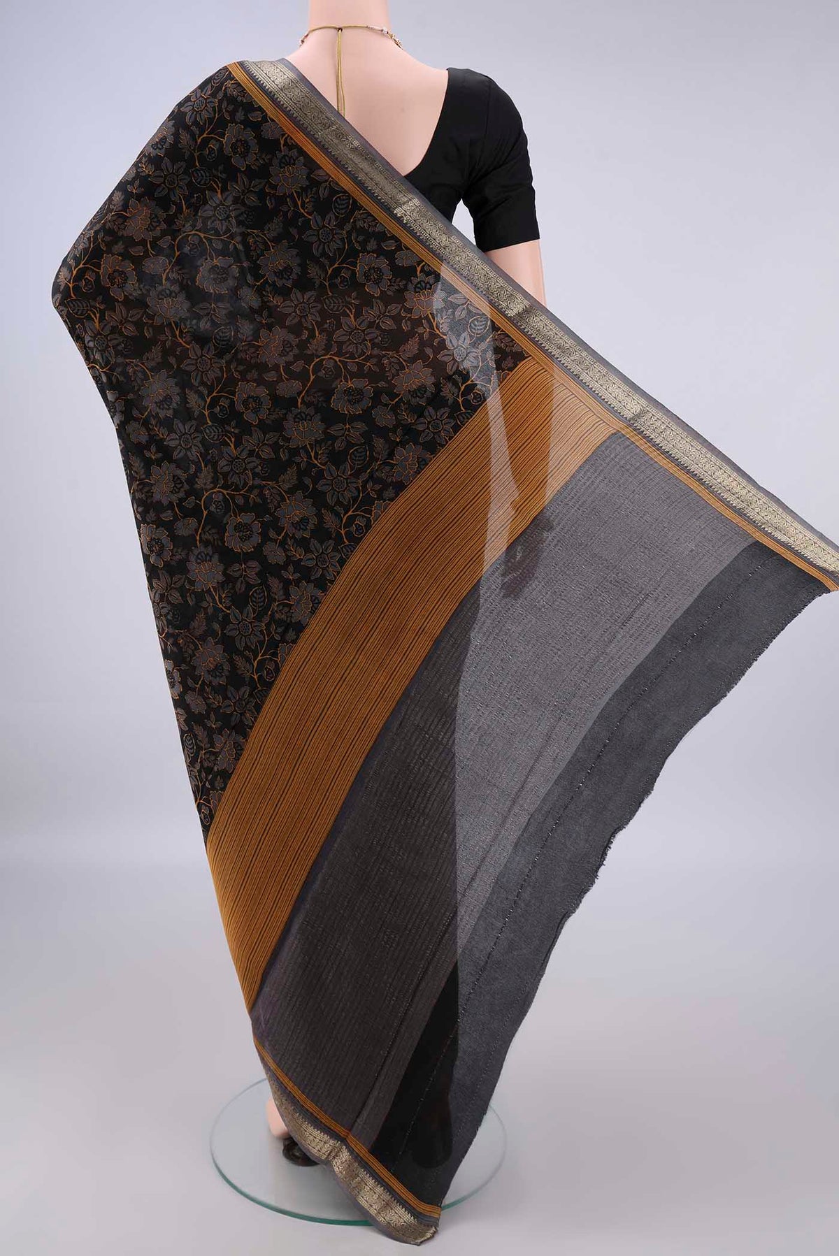 Flat view of Black Mysore Crepe Saree with Printed design on the body and Zari Border. 