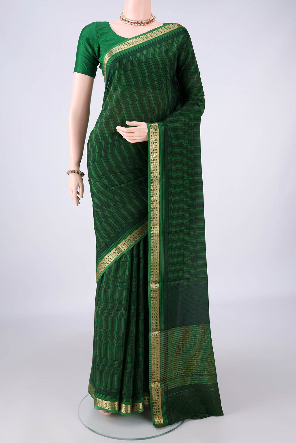 Bottle Green Mysore Crepe Saree with Printed design on the body and Zari Border.  displayed on a mannequin