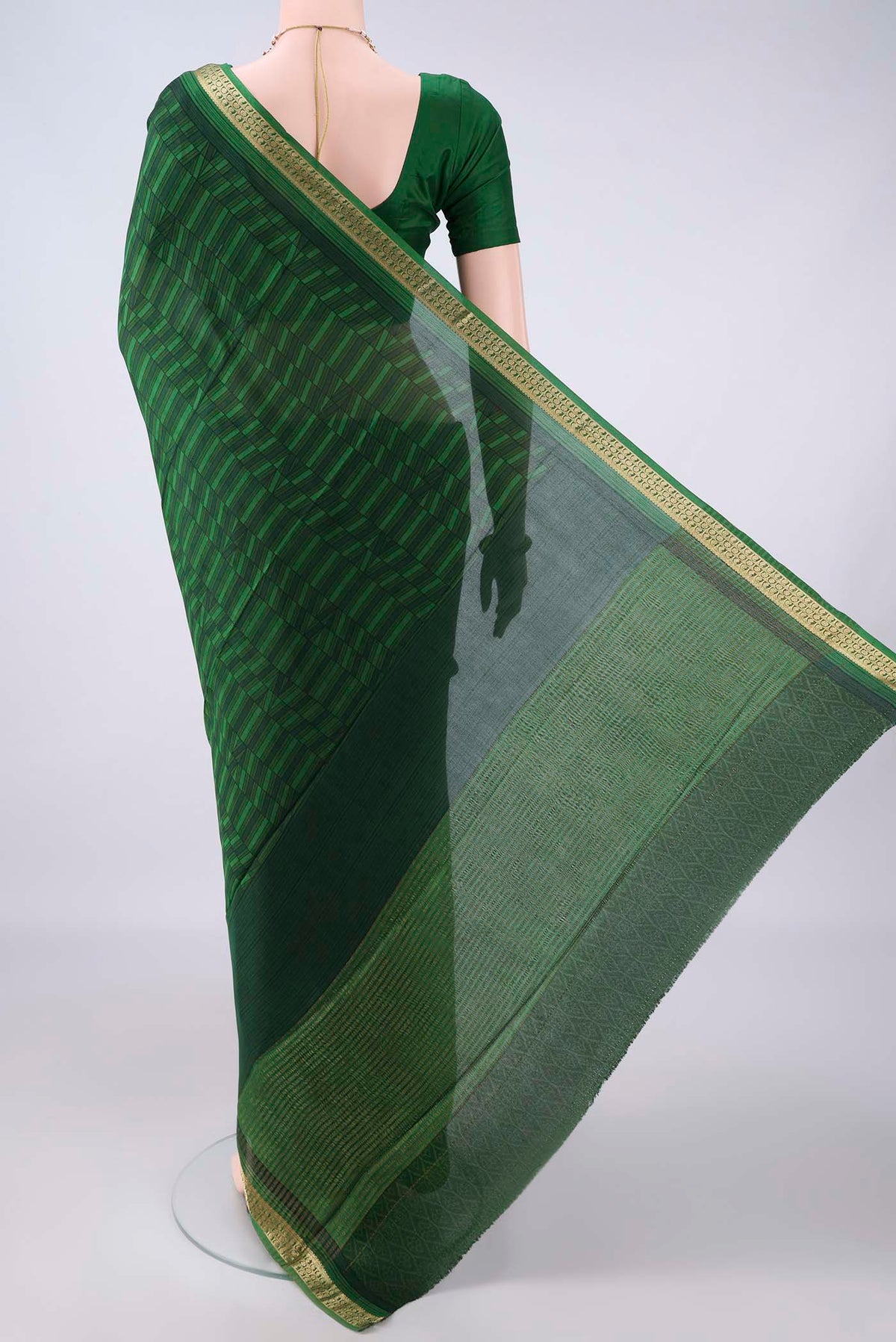 Flat view of Bottle Green Mysore Crepe Saree with Printed design on the body and Zari Border. 