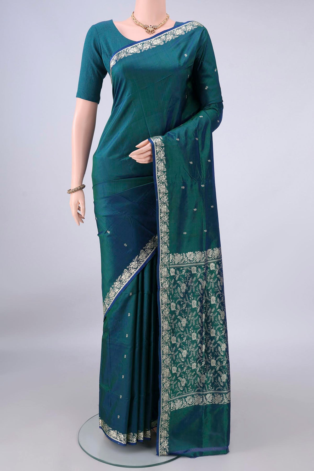 Pure Silk Peacock Blue Dual Tone Banarasi Katan Saree with Thread Butta on the body and Thread Border.  displayed on a mannequin