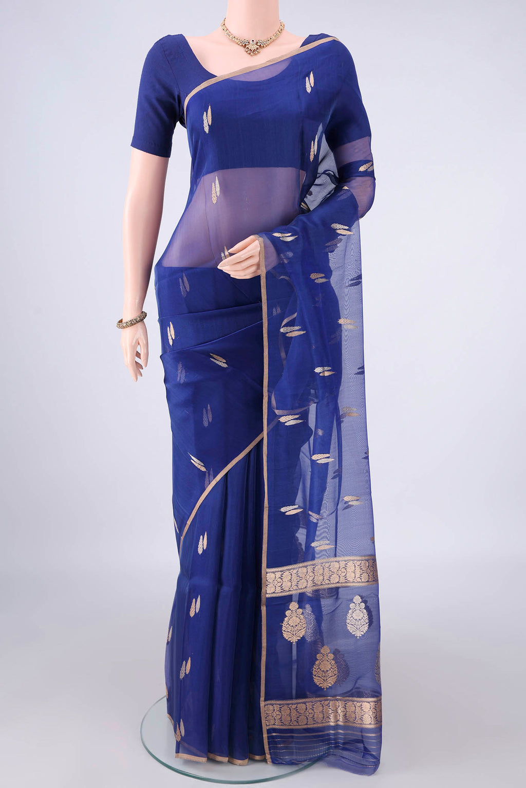 Royal Blue Organza Saree with Zari Butta on the body and Thin Zari Line.  displayed on a mannequin