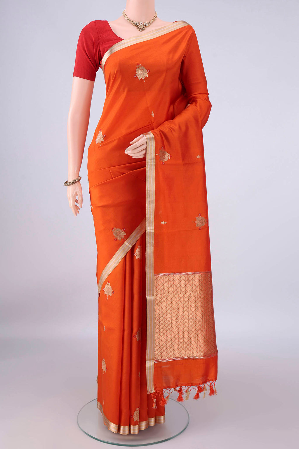 Pure Silk Orange Banarasi Katan Saree with Zari Butta on the body and Zari Border.  displayed on a mannequin