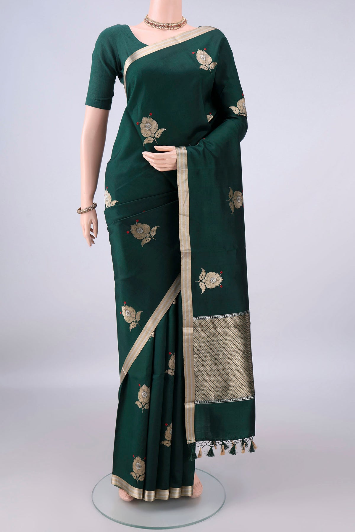Pure Silk Bottle Green Banarasi Katan Saree with Zari Butta on the body and Zari Border.  displayed on a mannequin