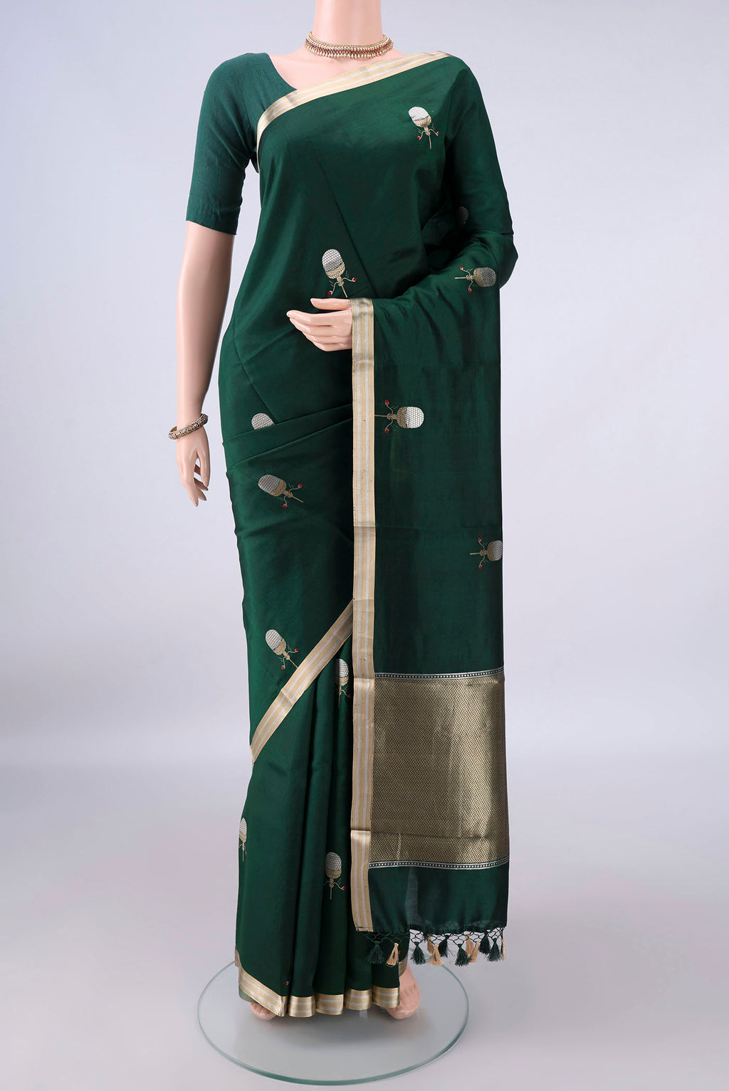 Pure Silk Bottle Green Banarasi Katan Saree with Zari Butta on the body and Zari Border.  displayed on a mannequin