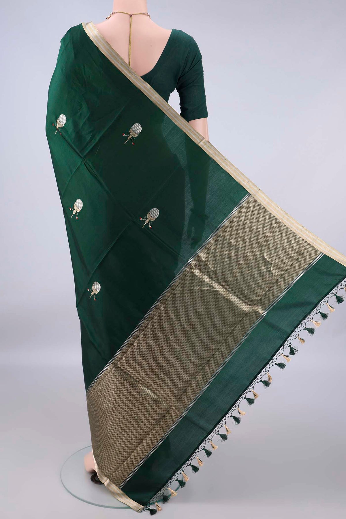 Flat view of Pure Silk Bottle Green Banarasi Katan Saree with Zari Butta on the body and Zari Border. 