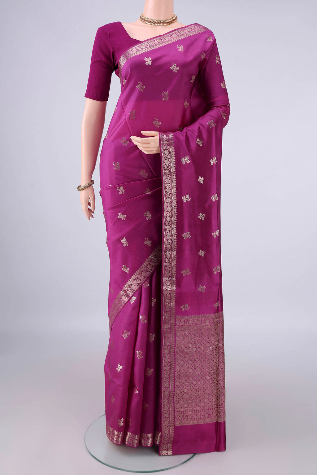 Pure Silk Magenta Banarasi Raw Saree with Zari Butta on the body and Zari Border.  displayed on a mannequin