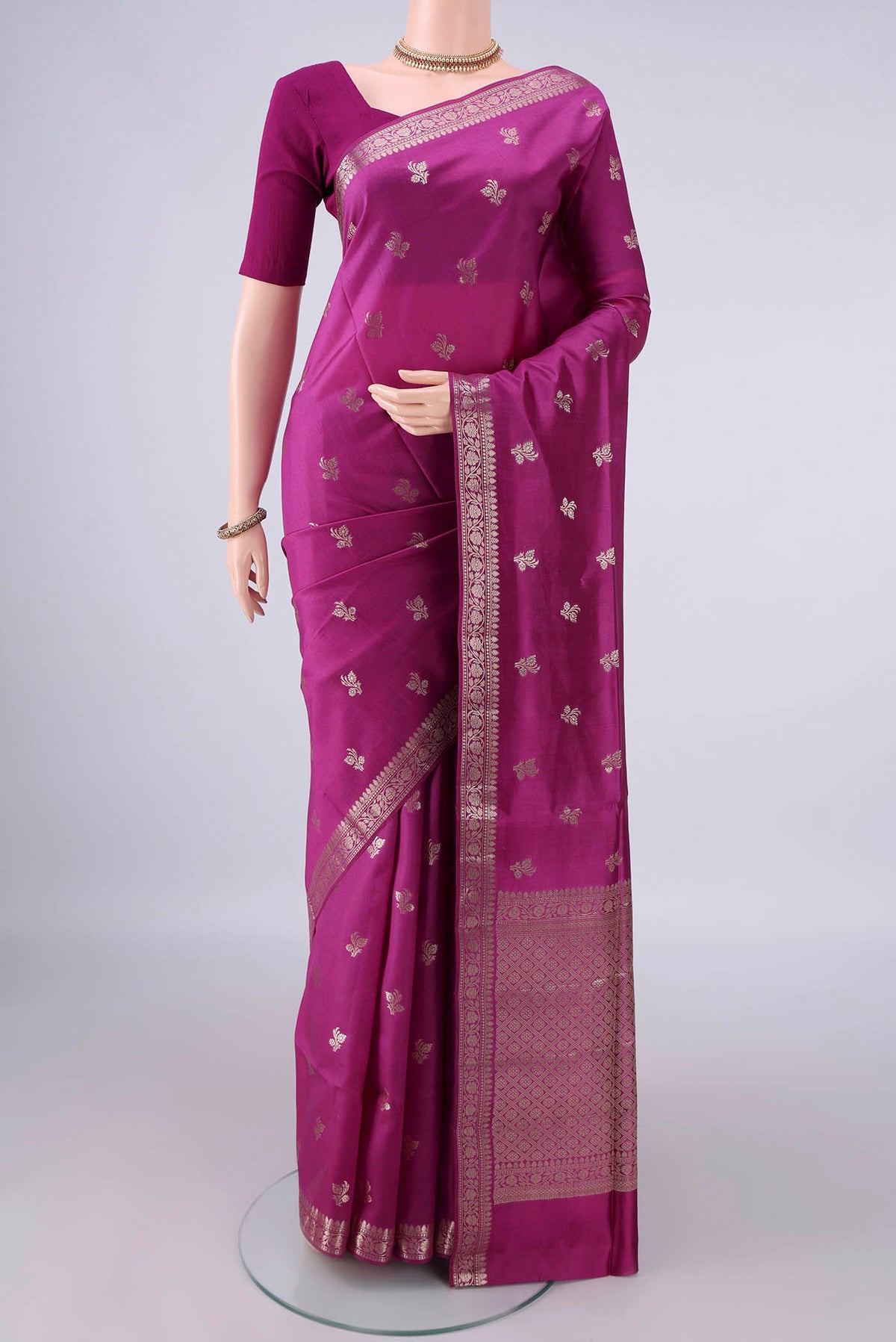 Pure Silk Magenta Banarasi Raw Saree with Zari Butta on the body and Zari Border.  displayed on a mannequin