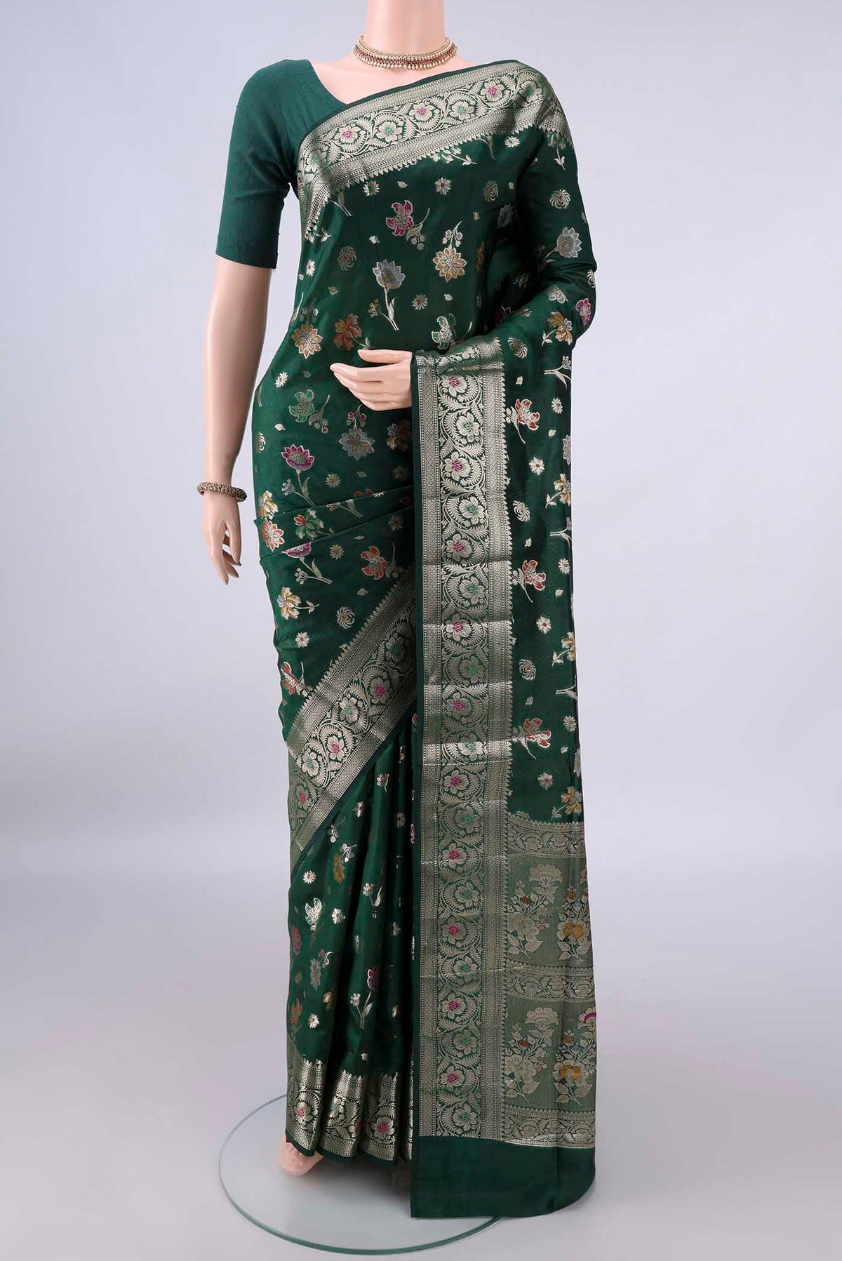 Pure Silk Bottle Green Banarasi Raw Saree with Zari Butta on the body and Zari And Thread Border.  displayed on a mannequin