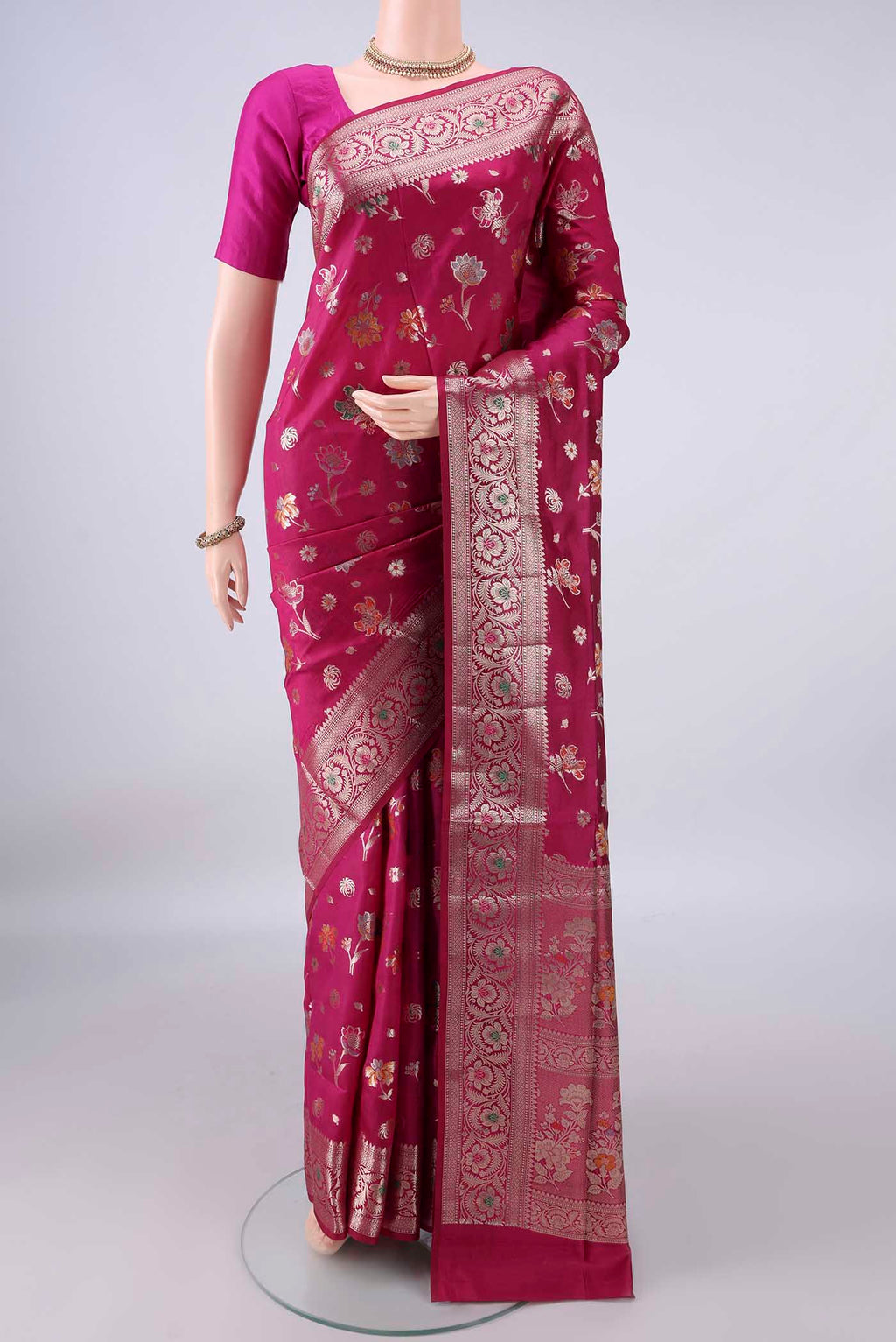 Pure Silk Rani Pink Banarasi Raw Saree with Zari Butta on the body and Zari And Thread Border.  displayed on a mannequin