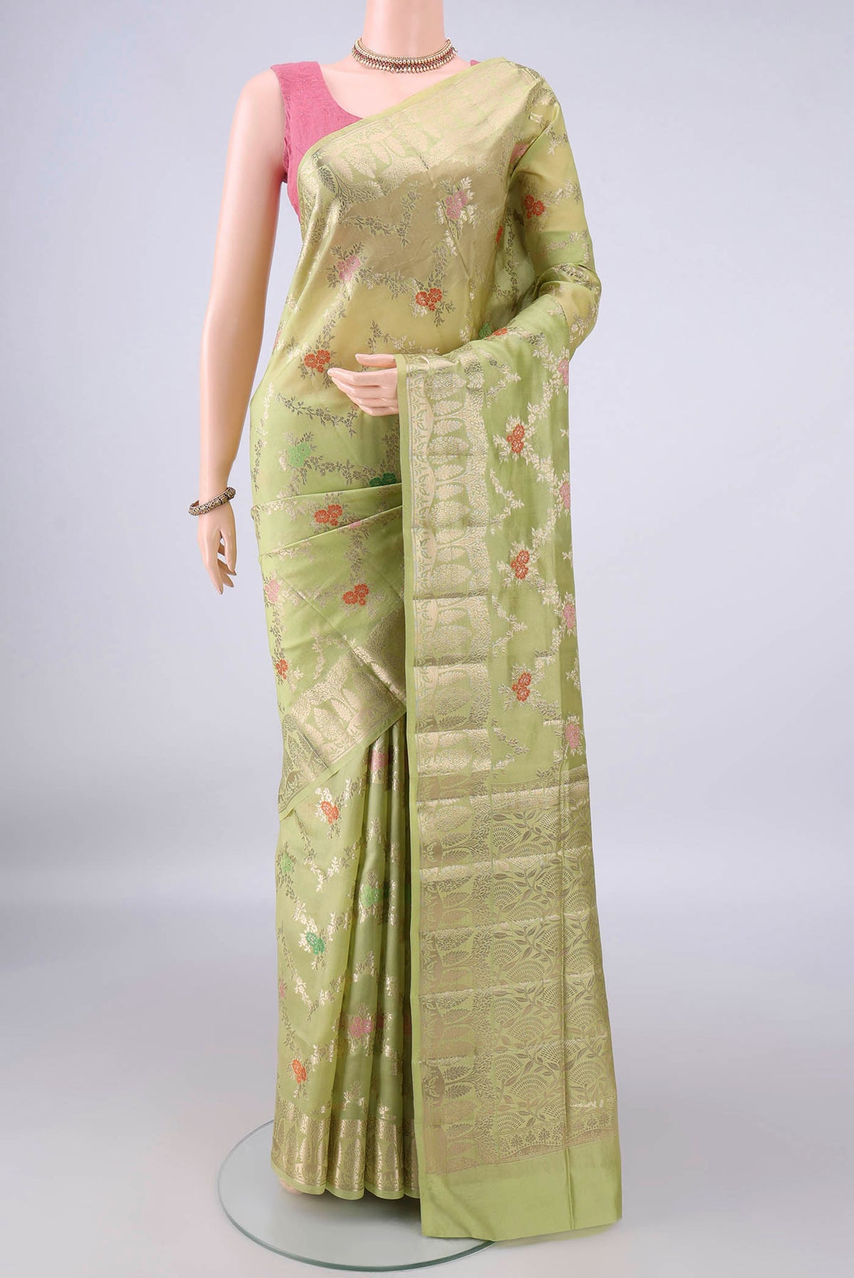 Pure Silk Light Green Banarasi Raw Saree with Zari Brocade on the body and Zari Border.  displayed on a mannequin