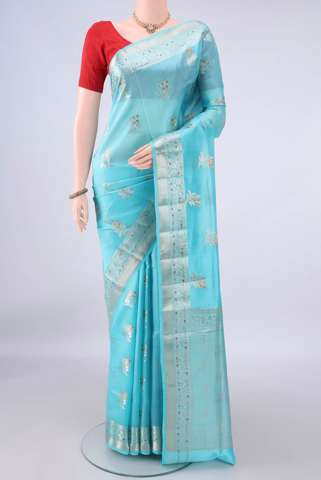 Pure Silk Sky Blue Banarasi Raw Saree with Zari Butta on the body and Zari Border.  displayed on a mannequin