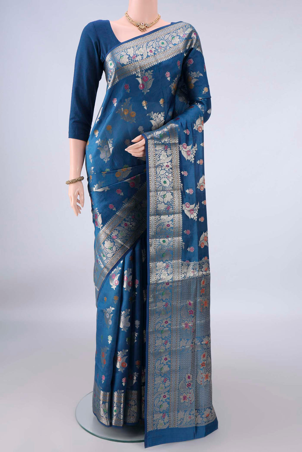 Pure Silk Blue Banarasi Raw Saree with Zari Butta on the body and Zari And Thread Border.  displayed on a mannequin