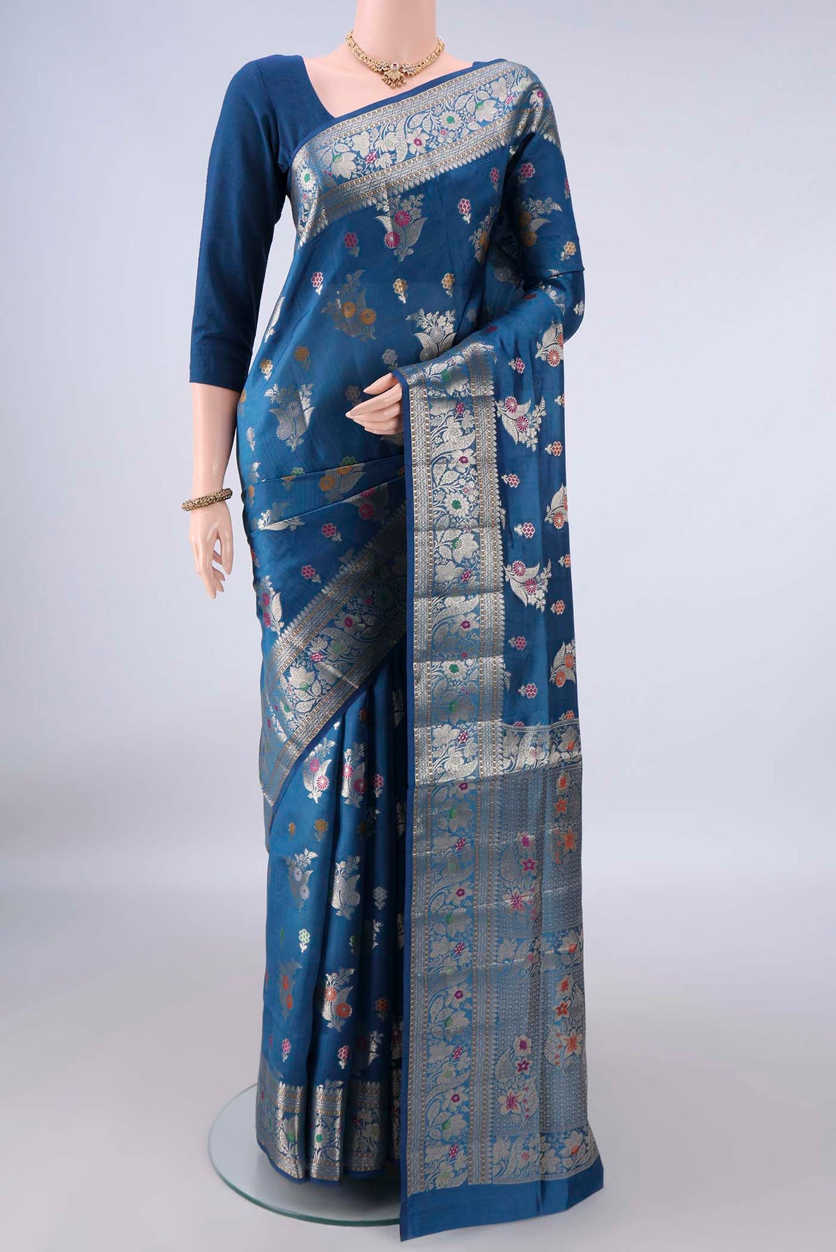 Pure Silk Blue Banarasi Raw Saree with Zari Butta on the body and Zari And Thread Border.  displayed on a mannequin