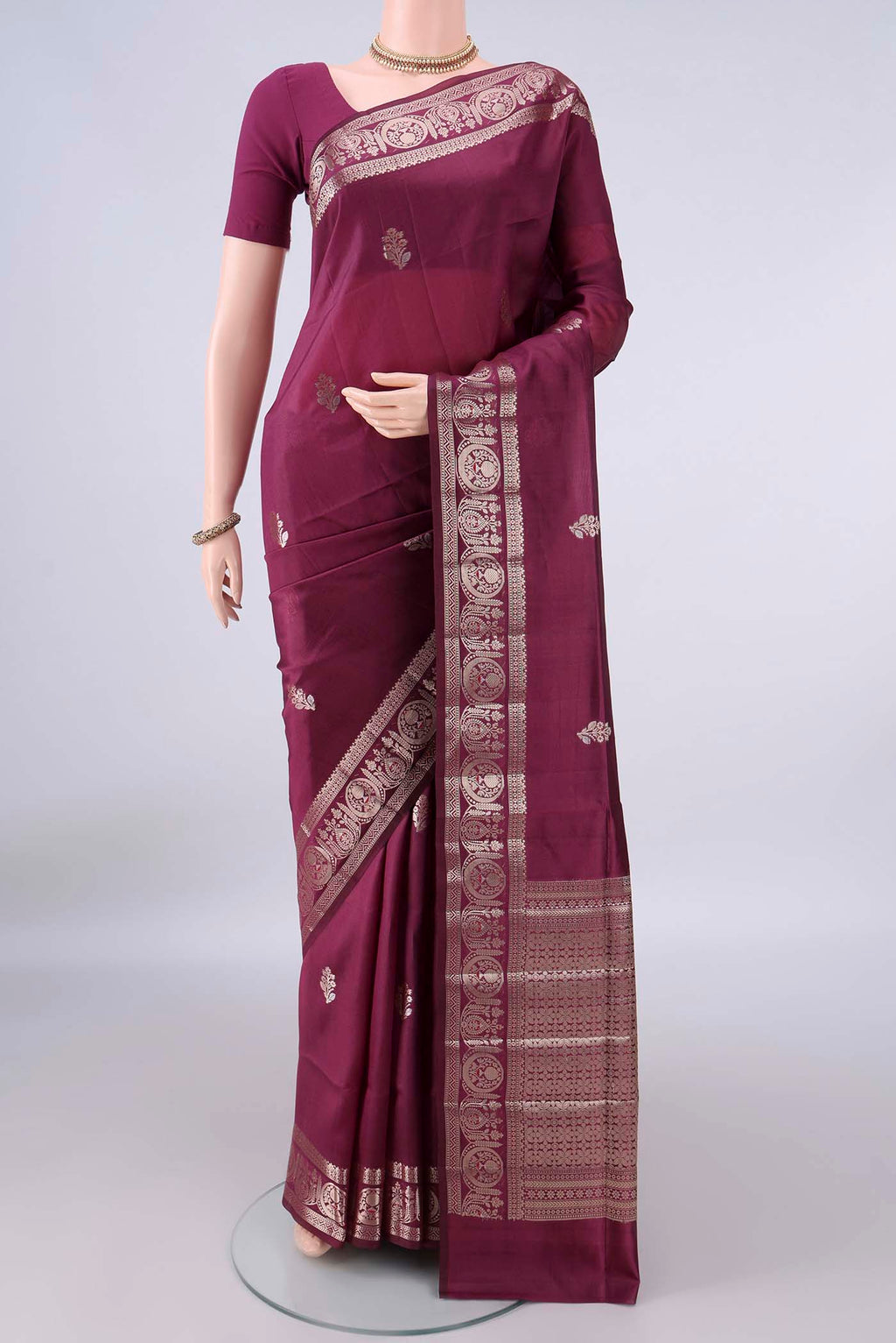 Pure Silk Burgundy Banarasi Raw Saree with Zari Butta on the body and Zari Border.  displayed on a mannequin