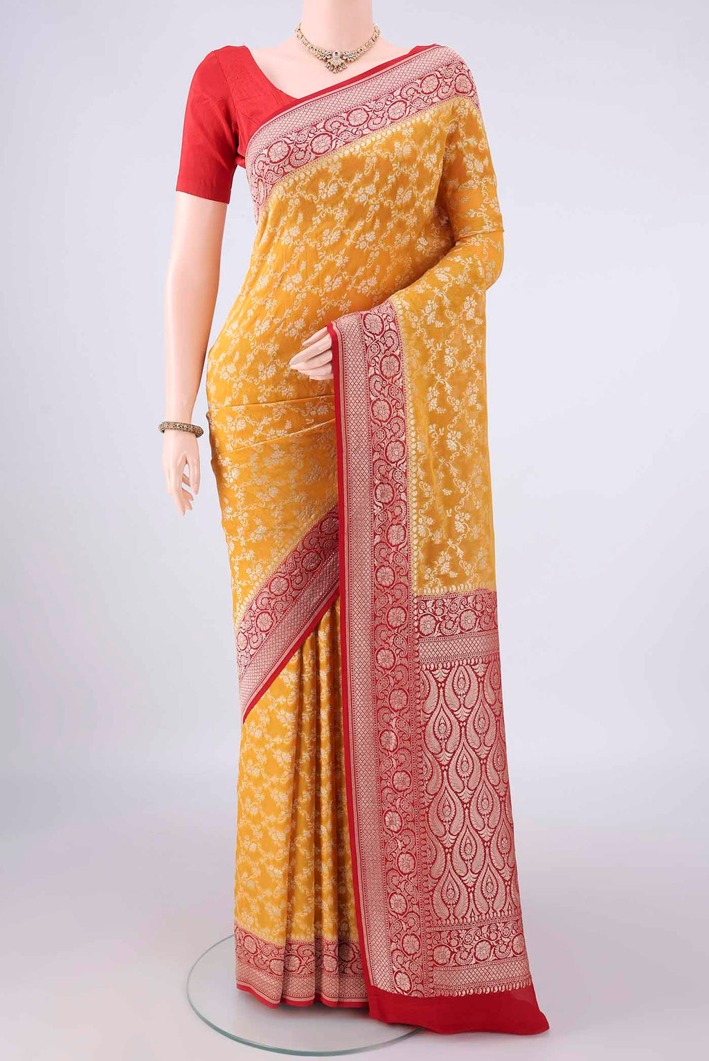 Yellow Banarasi Georgette Saree with Zari Brocade on the body and Zari Border.  displayed on a mannequin