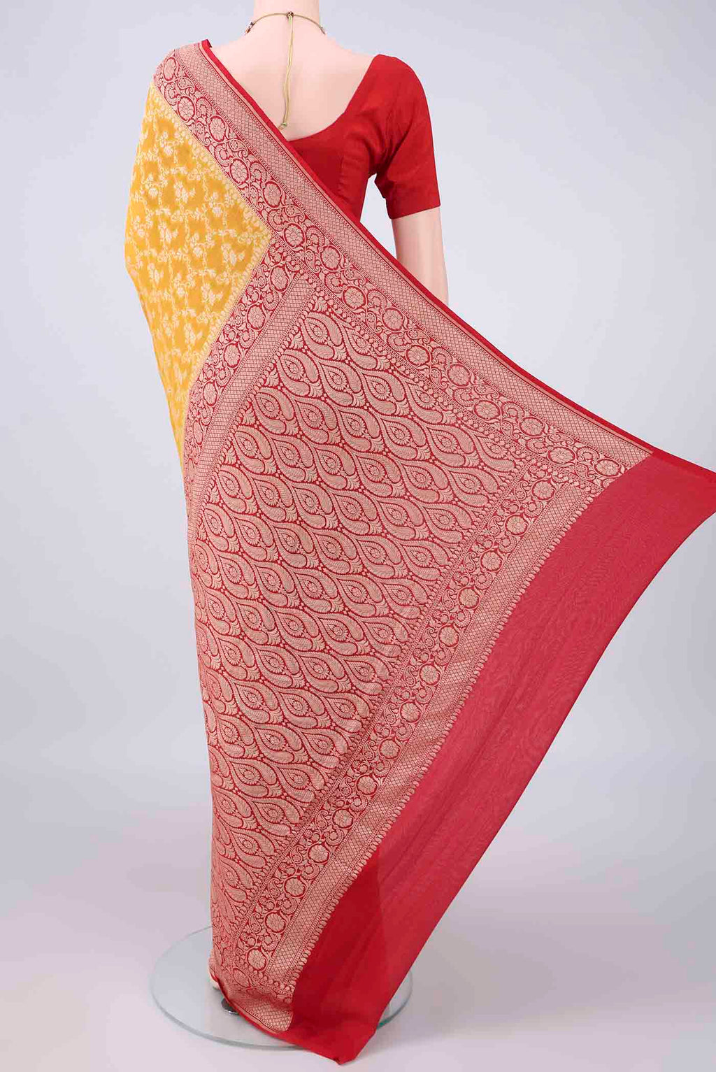 Flat view of Yellow Banarasi Georgette Saree with Zari Brocade on the body and Zari Border. 