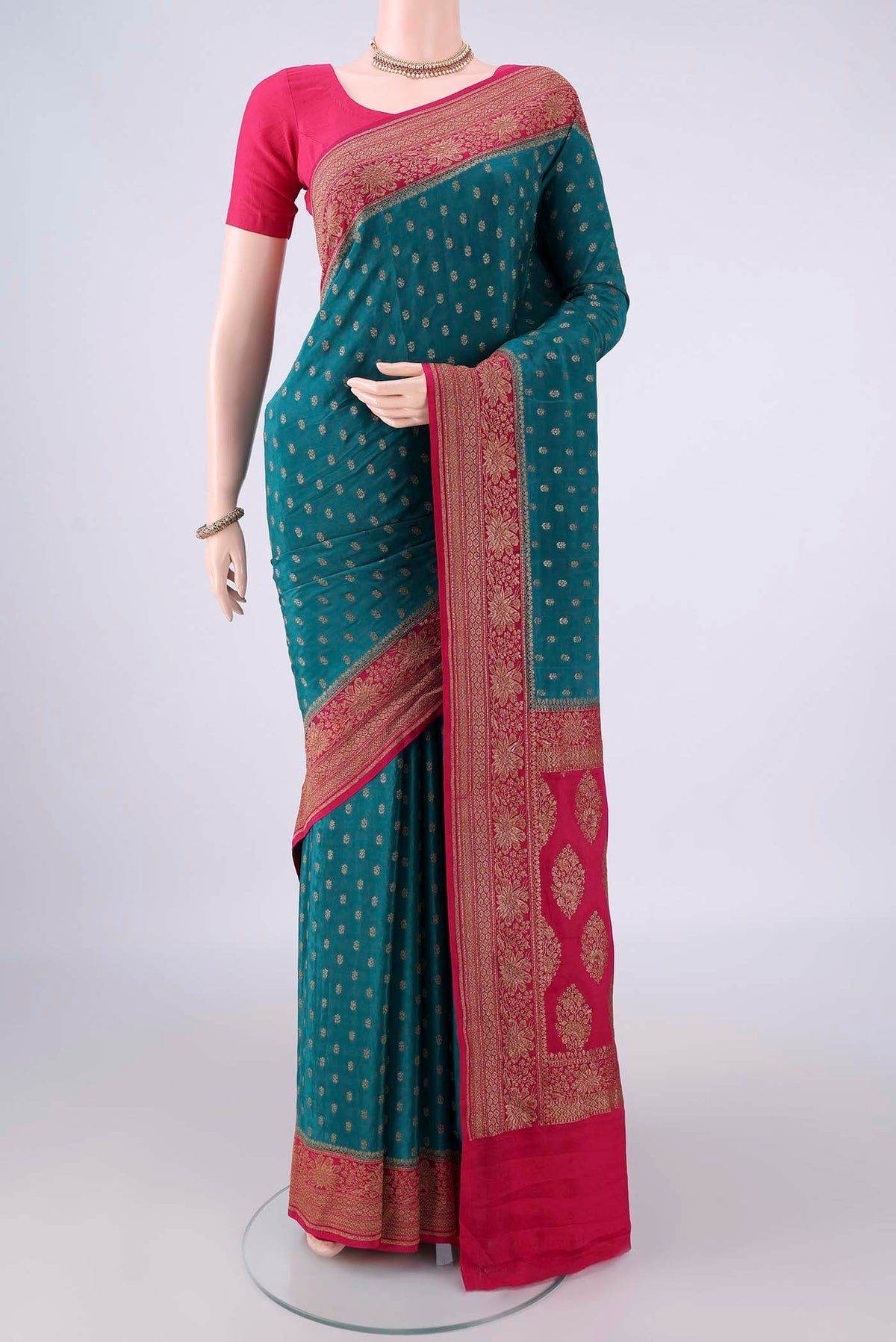 Teal Banarasi Georgette Saree with Zari Butta on the body and Zari Border.  displayed on a mannequin