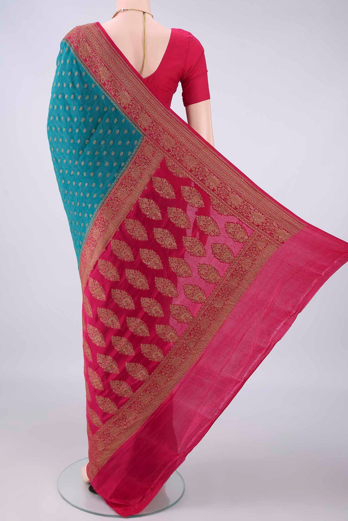 Flat view of Teal Banarasi Georgette Saree with Zari Butta on the body and Zari Border. 