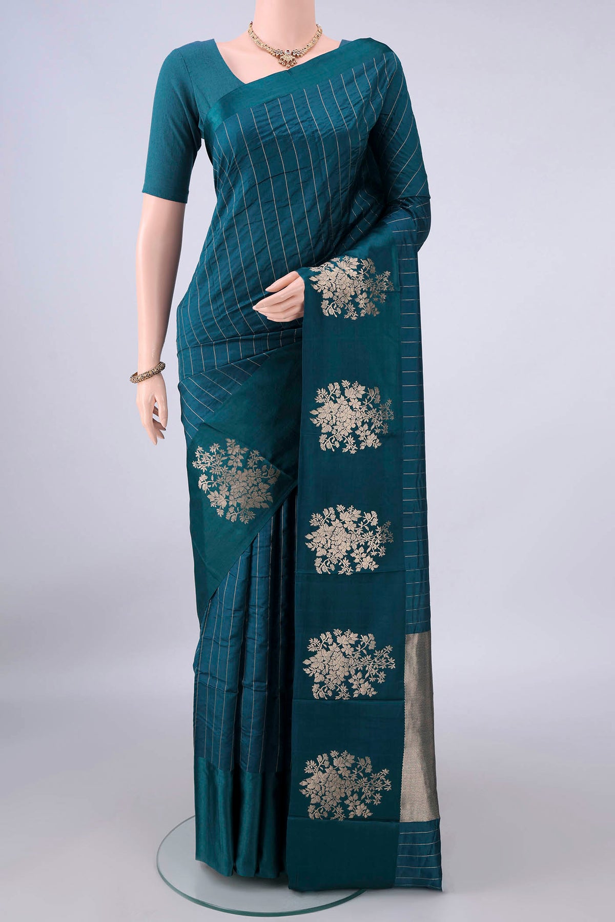 Pure Silk Teal Banarasi Katan Saree with Stripes on the body and Zari Border.  displayed on a mannequin
