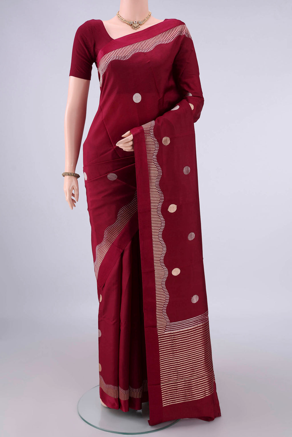 Pure Silk Maroon Banarasi Katan Saree with Zari Butta on the body and Zari Border.  displayed on a mannequin