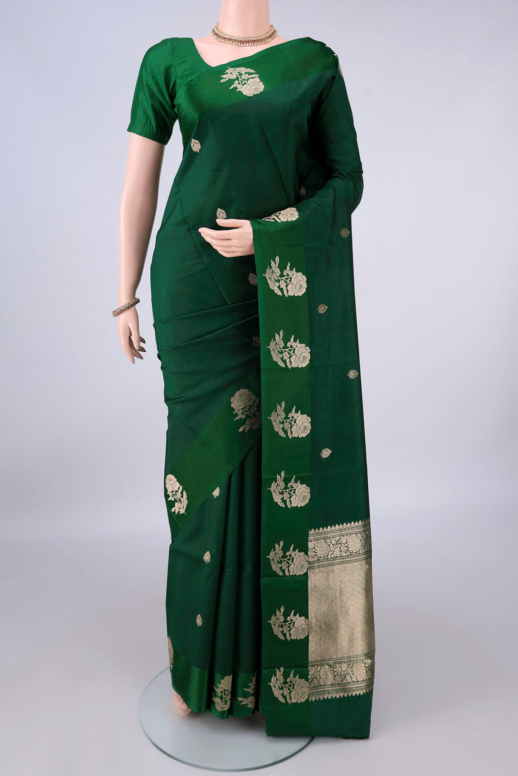Pure Silk Bottle Green Banarasi Katan Saree with Zari Butta on the body and Zari Border.  displayed on a mannequin