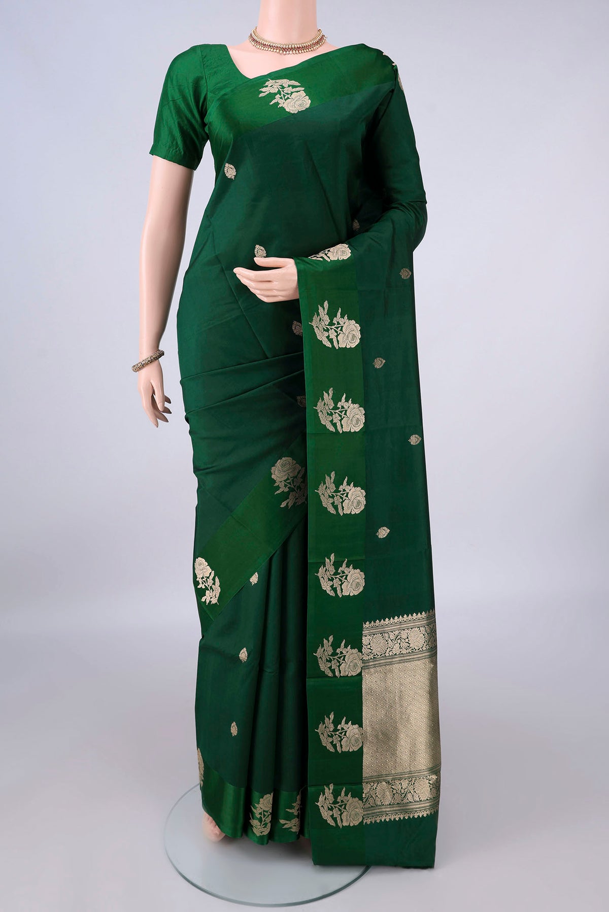 Pure Silk Bottle Green Banarasi Katan Saree with Zari Butta on the body and Zari Border.  displayed on a mannequin