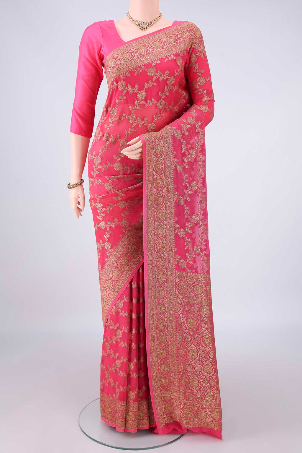 Coral Banarasi Georgette Saree with Zari Brocade on the body and Zari Border.  displayed on a mannequin