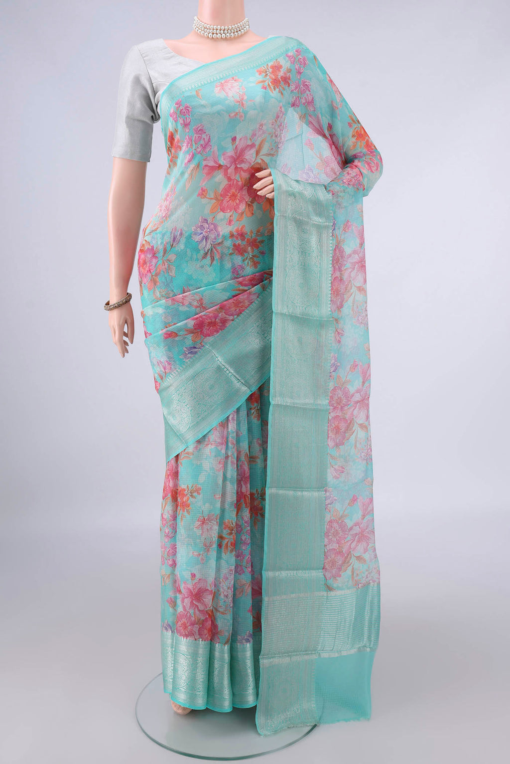 Pure Silk Turquoise Kota Saree with Floral Print on the body and Zari Border.  displayed on a mannequin