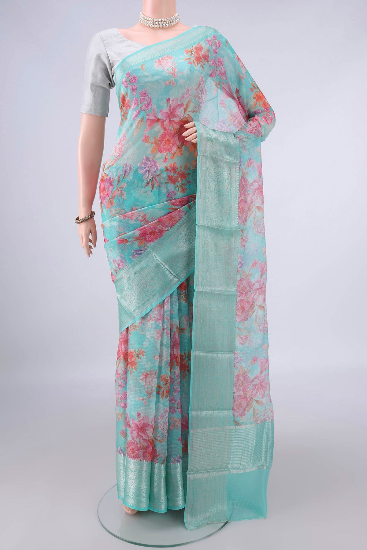 Pure Silk Turquoise Kota Saree with Floral Print on the body and Zari Border.  displayed on a mannequin