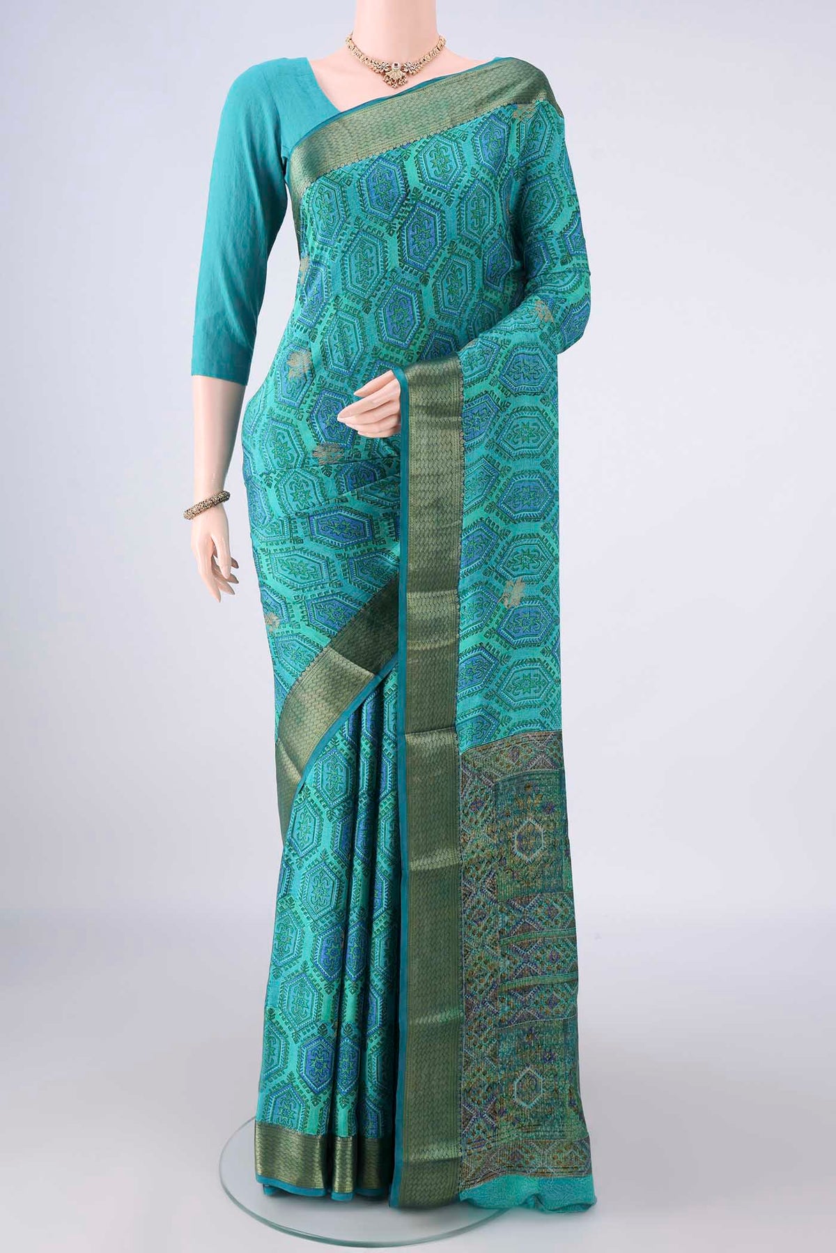 Turquoise Mysore Crepe Saree with Printed design on the body and Zari Border.  displayed on a mannequin