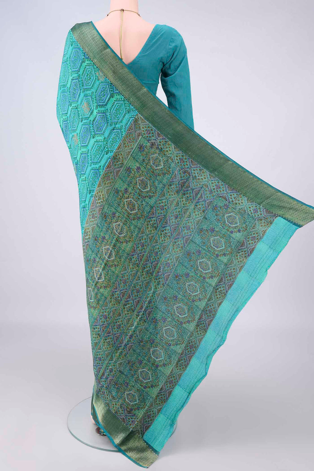 Flat view of Turquoise Mysore Crepe Saree with Printed design on the body and Zari Border. 