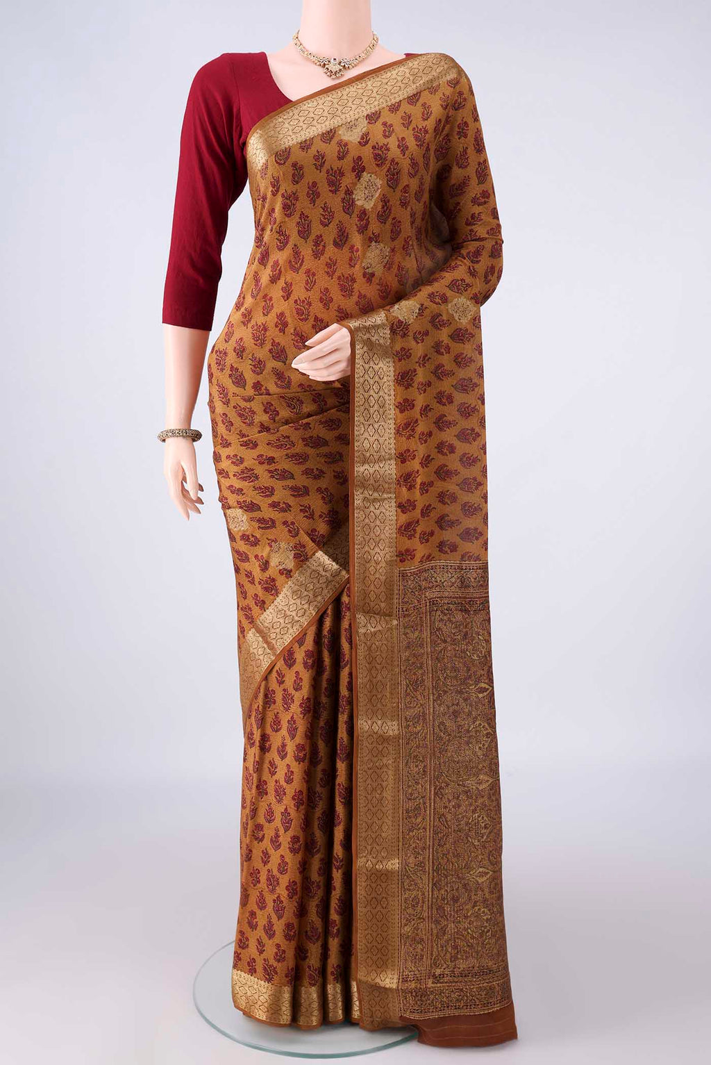 Mustard Mysore Crepe Saree with Printed design on the body and Zari Border.  displayed on a mannequin