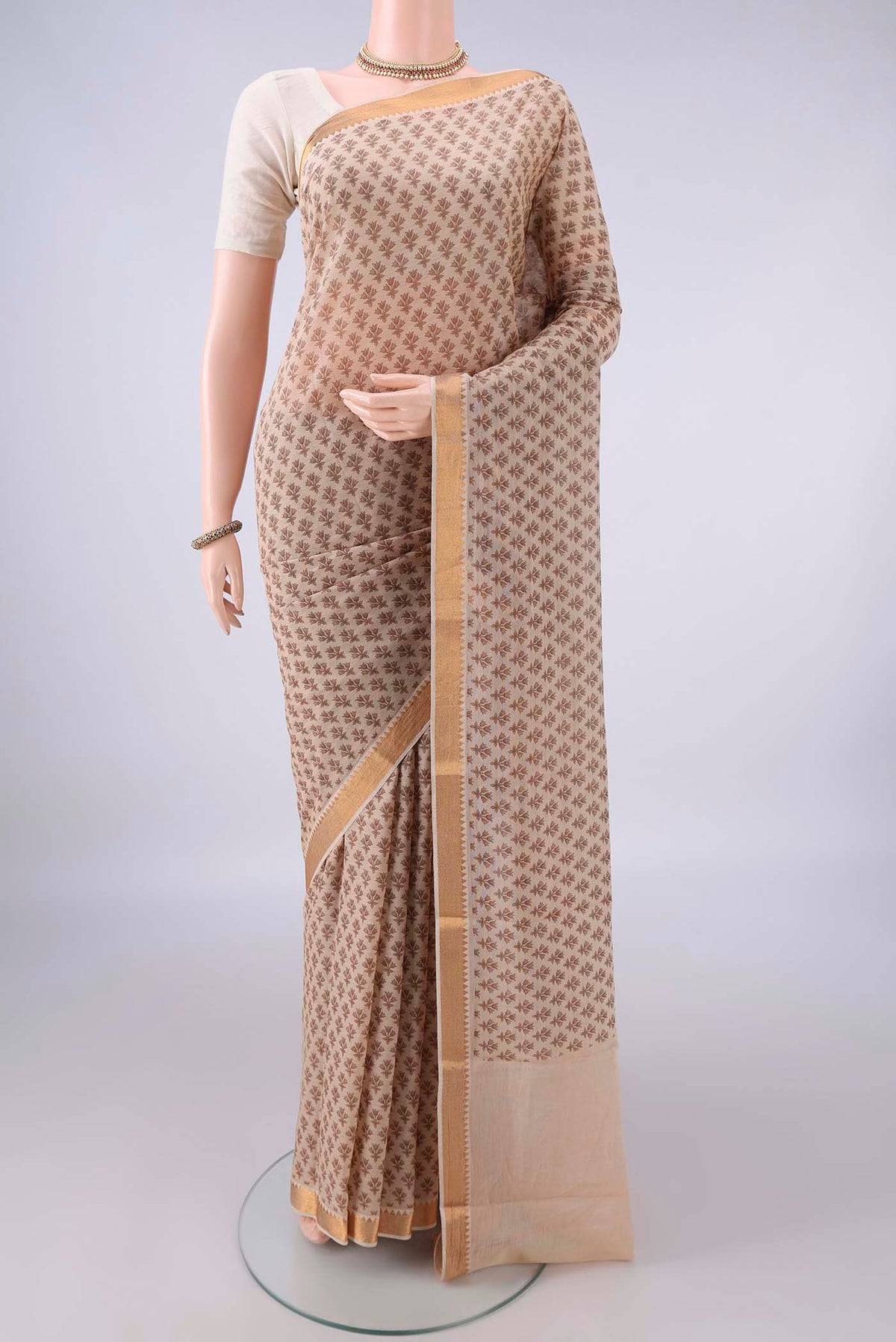 Beige Mangalagiri Cotton Saree with Floral Print on the body and Zari Border.  displayed on a mannequin